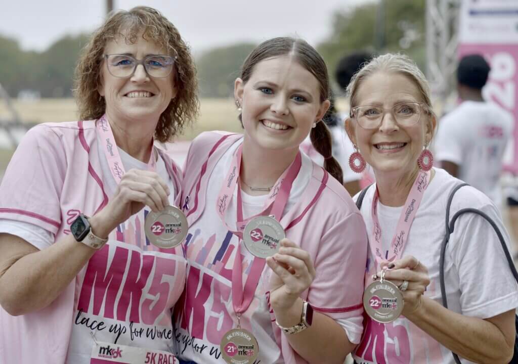 three women with medals for finishing the MK5K race at Mary Kay